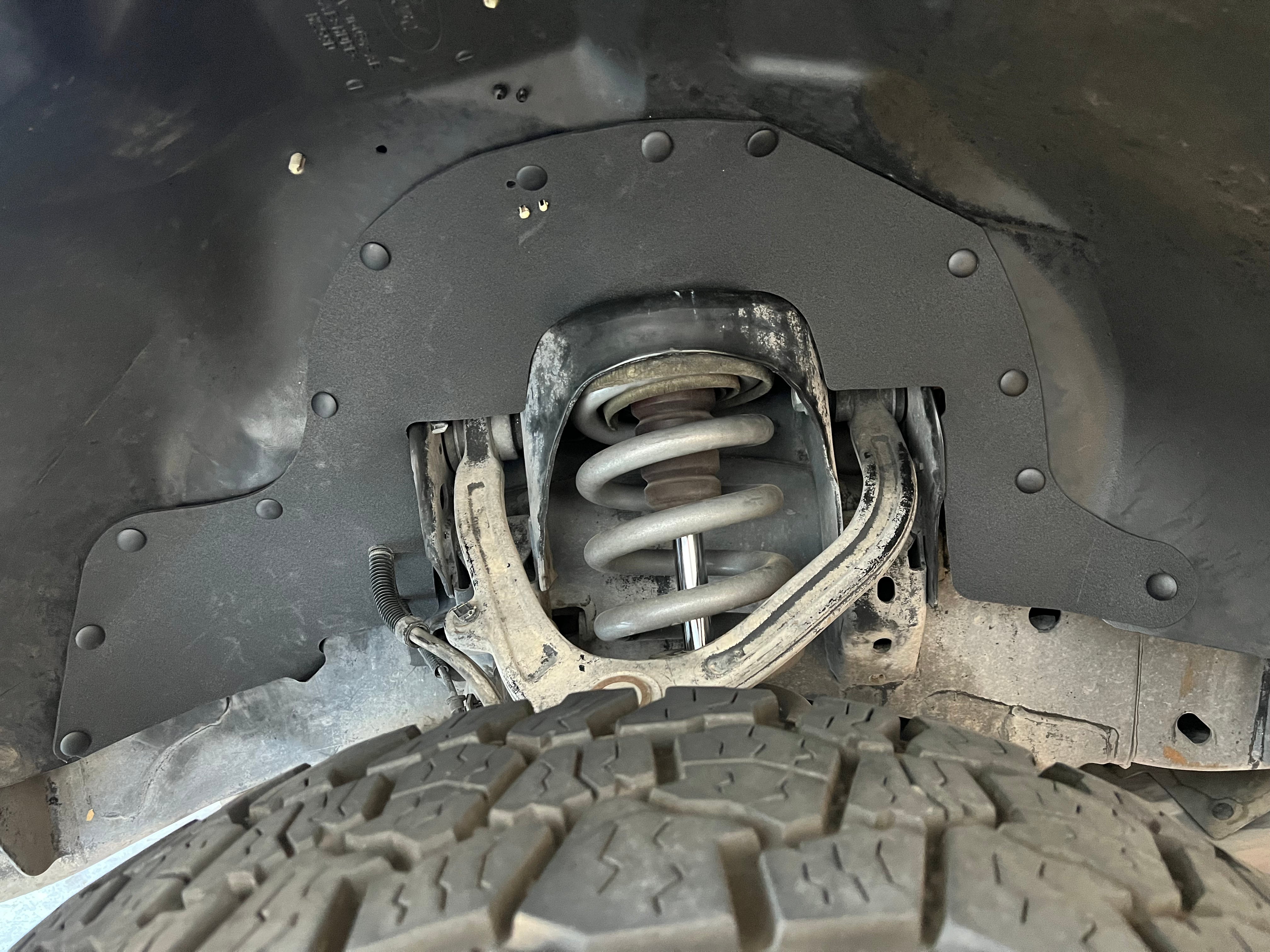 2010-2014 Ford Raptor Driver Side front wheel well with Ark Splash Guards covering up exposed engine bay behind suspension